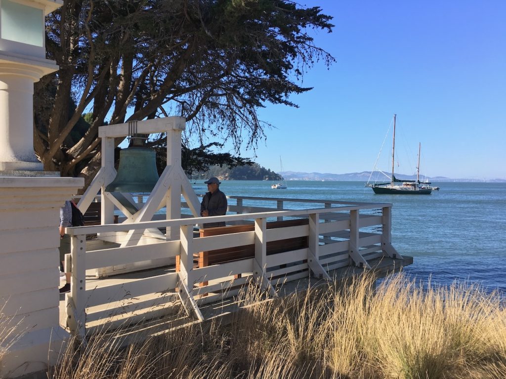 large bell on a pier overlooking the bay